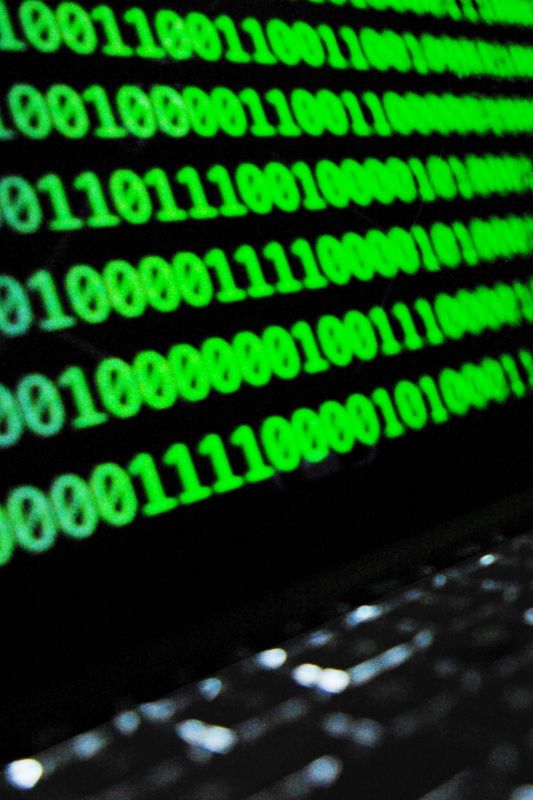 Hackerangriff auf einem Bildschirm mit grünen Nullen und Einsern als Beispiel für DSGVO-Schmerzensgelder